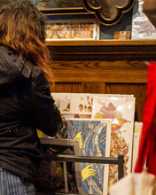 Load image into Gallery viewer, A woman looking at a display of Indeed Brewing Company&#39;s Chuck U Prints.
