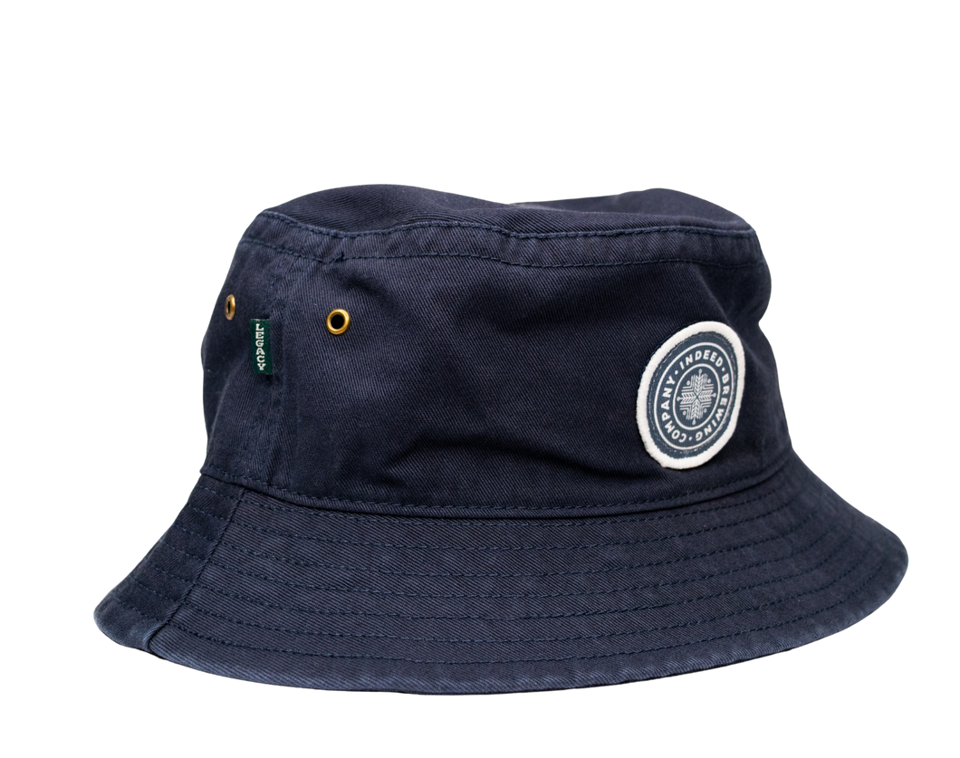 An Indeed Bucket Hat by Legacy with a white patch on it.